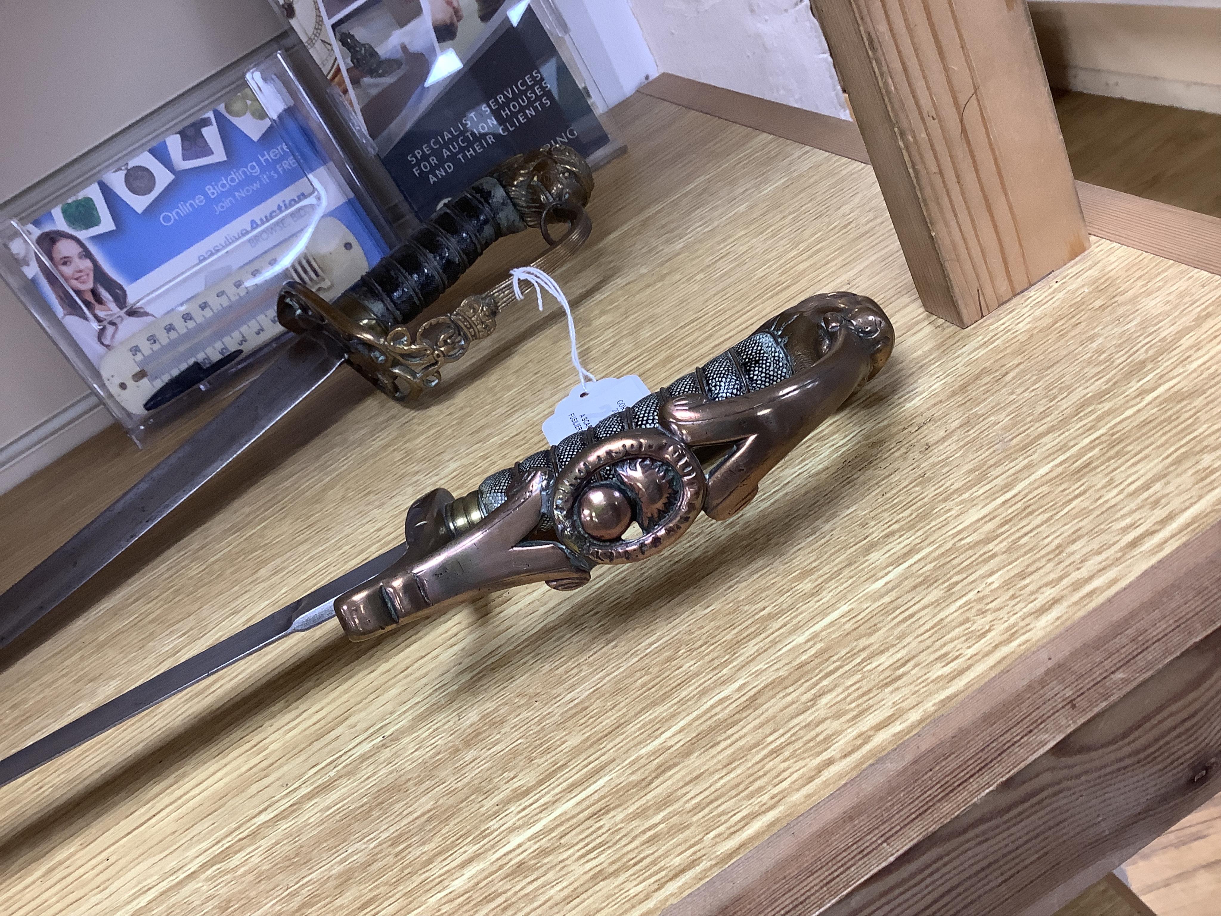 A scarce Scottish Fusiliers NCO‘s sword, with regulation stirrup hilt, regimental badge, lion’s head pommel, wire bound grip, plain blade, together with an 1803 infantry officer’s sword with regulation brass hilt, wire b